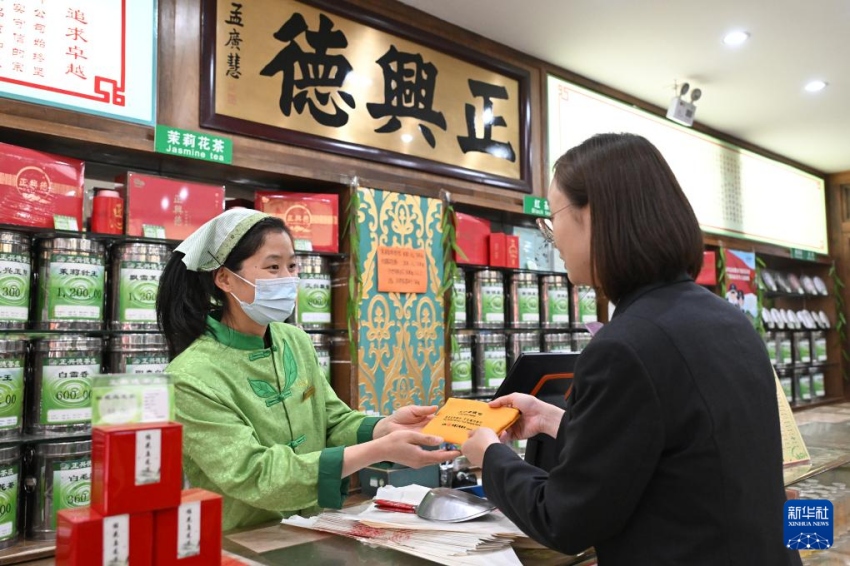 4월 29일 공상은행 베이징 시허옌(西河沿)지점의 직원(오른쪽)이 정싱더 찻집 다스란점 직원에게 ‘공상은행 잔돈지갑’을 건네고 있다.