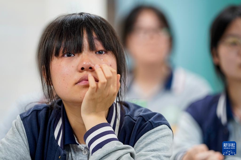 한 학생이 지난 고등학교 생활 영상을 보며 눈물을 흘린다. [5월 31일 촬영/사진 출처: 신화사]