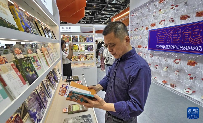 관람객이 박람회 홍콩관에서 책을 읽는다. [6월 19일 촬영/사진 출처: 신화사]