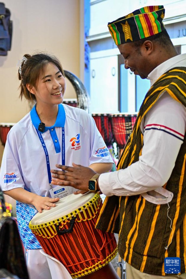 6월 26일, 가나 전시부스에서 자원봉사자가 타악기 연주법을 배우고 있다.