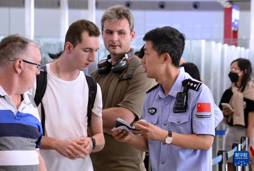 베이징 서우두공항 변경검문소 민경이 외국인 관광객들의 비자면제 입국 관련 질문에 답한다. [7월 10일 촬영/사진 출처: 신화사]