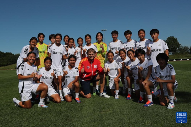 독일 헤르초겐아우라흐에서 ‘추봉계획’ 여자 청소년 축구팀원과 비에른 굴덴 아디다스 글로벌 CEO가 기념사진을 찍는다. [8월 12일 촬영/사진 출처: 신화사]