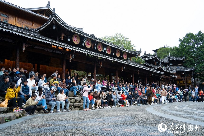 마을 광장에는 공연을 관람하는 관광객들로 가득 차 있다. [사진 출처: 인민망]