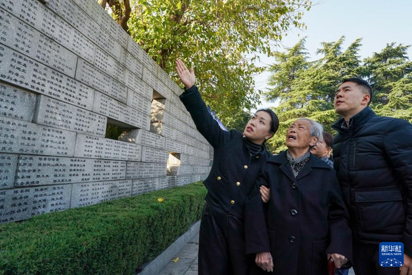 12월 1일 난징대학살 생존자 아이이잉 씨(가운데)가 ‘통곡의 벽’에서 가족의 이름을 찾고 있다. [사진 출처: 신화사]