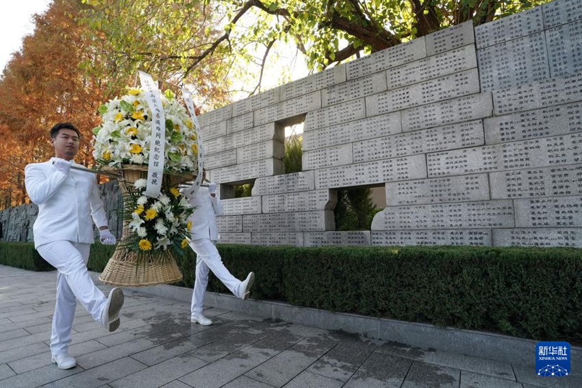 12월 1일 난징대학살 희생자 가족 제사 행사에서 관계자가 꽃다발을 헌화하고 있다. [사진 출처: 신화사]