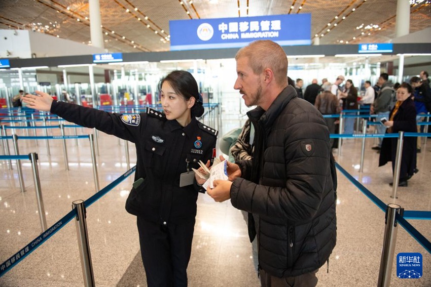 출입국심사 경찰이 베이징 서우두공항 제3터미널 입국장에서 외국인 관광객을 안내하고 있다. [12월 4일 촬영/사진 출처: 신화망]