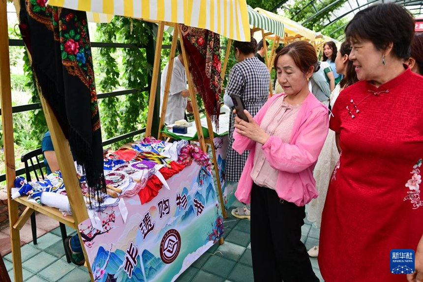 제유궁주 라벤더 농장에서 관광객들이 무형문화재 시장을 구경하며 사진을 찍고 있다. [6월 14일 촬영/사진 출처: 신화사]