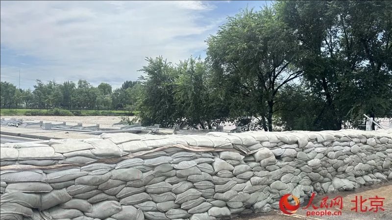 무장경찰대원들이 모래 10만여 포대를 운반해 1100m 제방을 건설했다. [사진 출처: 인민망]