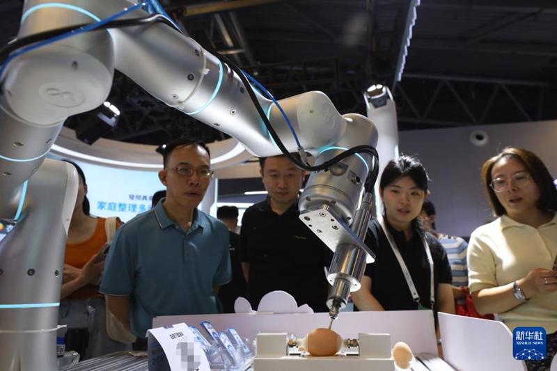 7월 29일, 관람객들이 달걀껍질을 조각하는 로봇 앞에서 발걸음을 멈추고 구경하고 있다.