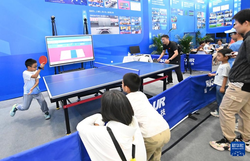 사람들이 스포츠서비스 전시장에서 탁구 스마트시스템을 체험한다. [9월 14일 촬영/사진 출처: 신화사]