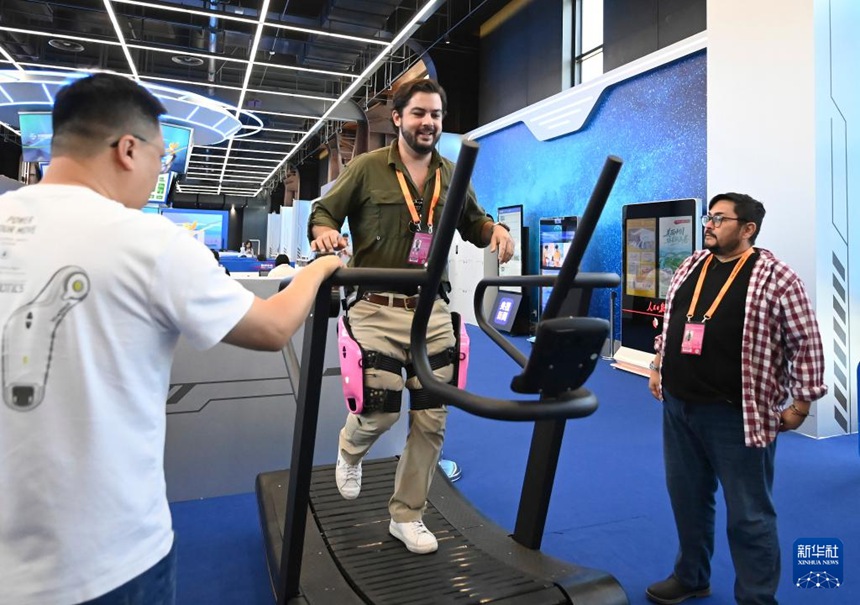 한 외국 기자가 교역회 프레스센터에서 ‘동력증강 외골격로봇’을 체험한다. [9월 14일 촬영/사진 출처: 신화사]