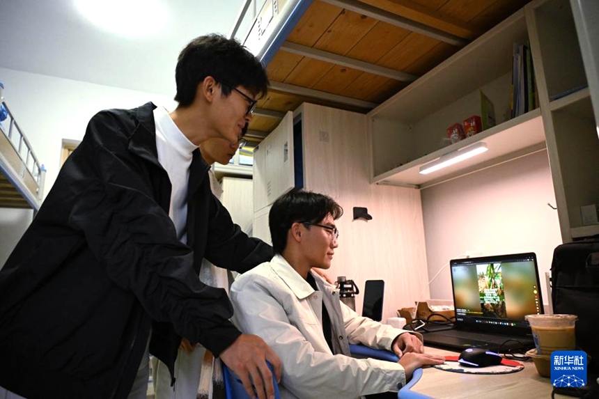 칭다오농업대학교 기숙사, 멍청은 친구들에게 찍어논 농사일 관련 영상을 보여준다. [10월 11일 촬영/사진 출처: 신화사]