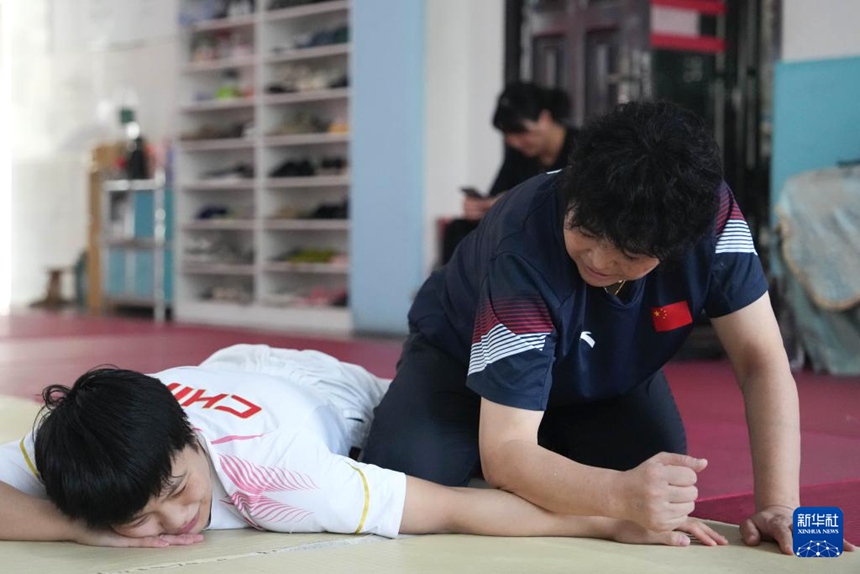 리웨화 코치가 장애인 체육훈련교육센터에서 스이제 선수의 훈련 후 스트레칭을 돕는다. [10월 8일 촬영/사진 출처: 신화사]