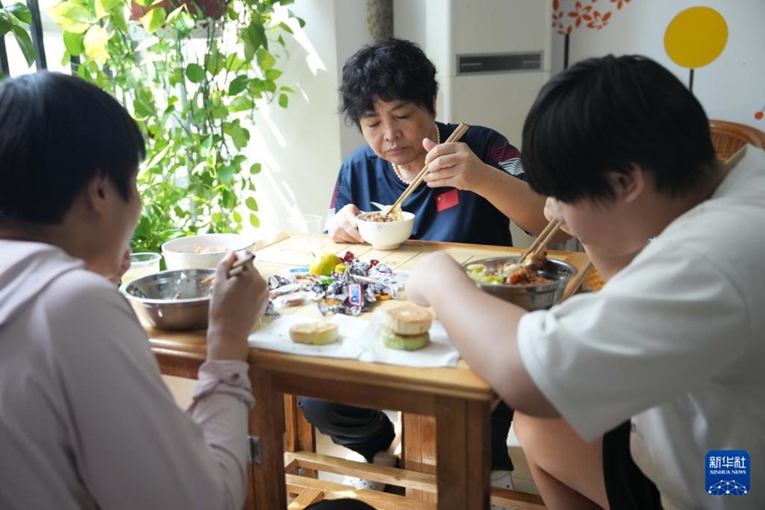 리웨화 코치가 기숙사에서 선수들과 함께 식사를 한다. [10월 8일 촬영/사진 출처: 신화사]