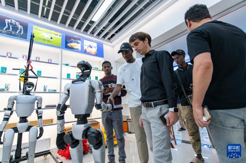 이우 글로벌 디지털 무역 센터에서 외국인 상인들이 로봇과 소통하고 있다. [10월 14일 촬영/사진 촬영: 후샤오페이(胡肖飛)]