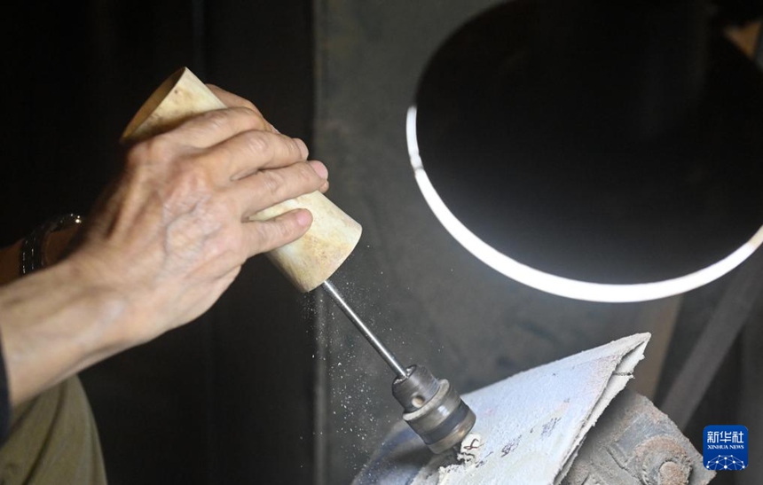 황이거가 자택에서 마골호의 공명통을 연마하고 있다. [10월 10일 촬영/사진 출처: 신화사]