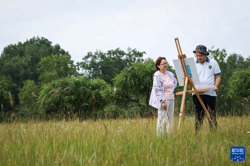 왕젠수가 엄마와 함께 허베이(河北)성 청더(承德)시 위다오커우(御道口) 초원에서 그림을 그리고 있다. [8월 18일 촬영/사진 출처: 신화사]