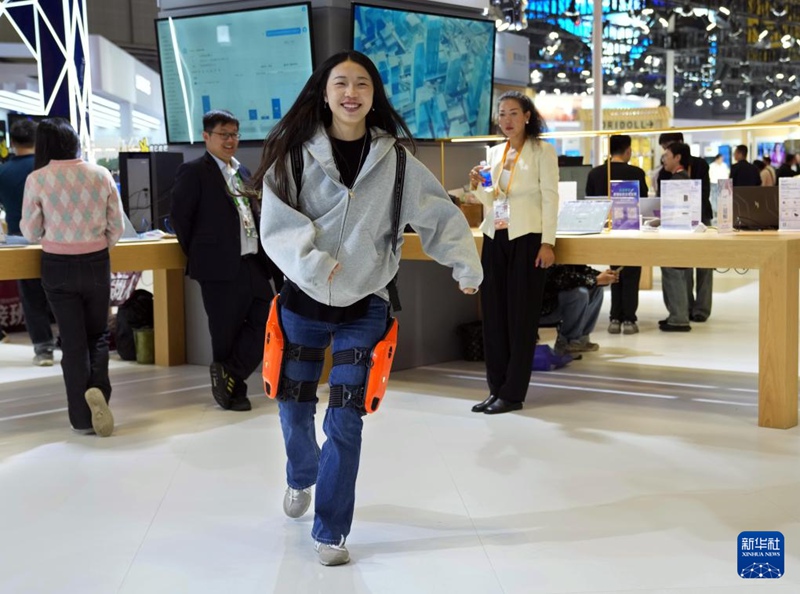 기술 장비 전시구에서 관람객이 착용형 외골격 로봇을 체험하고 있다. [11월 6일 촬영/사진 출처: 신화사]