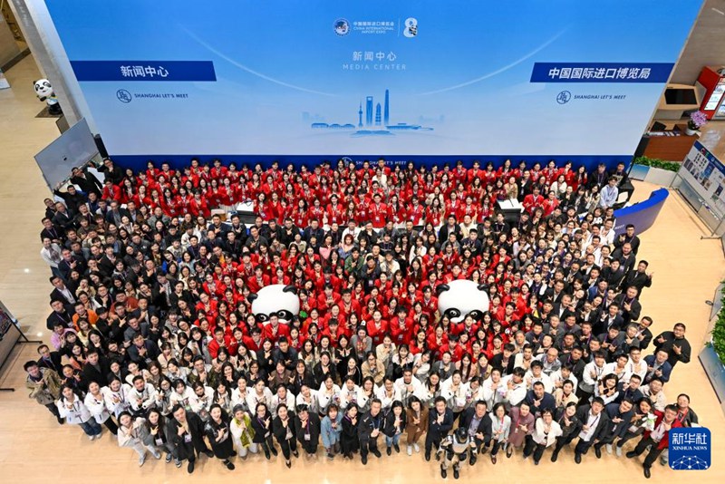 자원봉사자들과 직원들이 박람회 뉴스 센터에서 단체 사진을 찍고 있다. [11월 10일 촬영/사진 출처: 신화사]