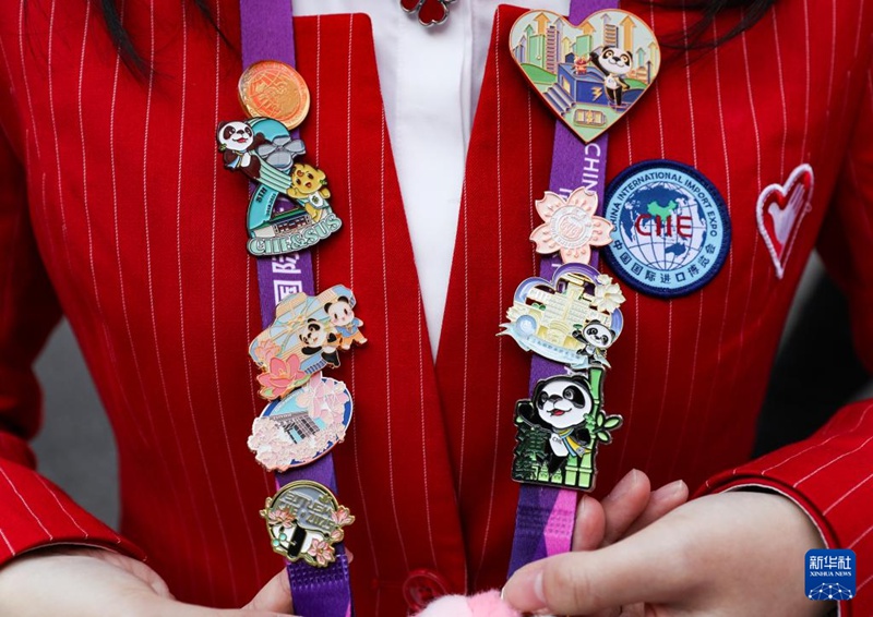 한 자원봉사자가 박람회에서 수집한 배지를 보여주고 있다. [11월 10일 촬영/사진 출처: 신화사]