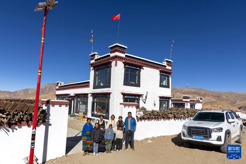 딩르현 취뤄(曲洛)향 러무칭(热木靑)촌 주민 니마핑춰(尼玛平措) 가족이 새집과 차량 앞에서 사진을 찍고 있다. [11월 12일 촬영/사진 출처: 신화사]