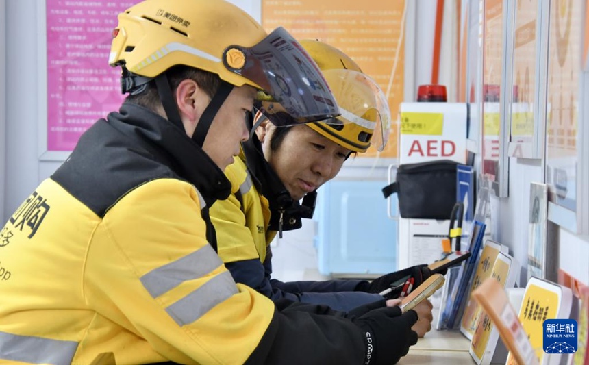 배달원들이 둥청구 한 휴게소에서 배터리 충전을 하며 휴식을 취하고 있다. [11월 26일 촬영/사진 출처: 신화사]