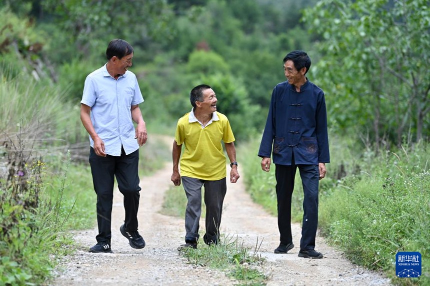 마을 간부 선광쥔(申廣軍)과 마을 주민 쌍젠궈(桑建國)가 친하이쑹을 돌볼 다음 주민 집으로 데려가고 있다. [2025년 8월 6일 촬영/사진 출처: 신화사]