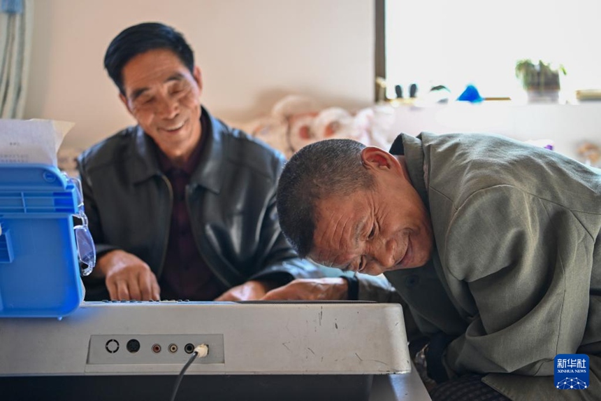 친하이쑹이 전자 오르간에서 나오는 소리를 들어보고 있다. [2025년 10월 14일 촬영/사진 출처: 신화사]