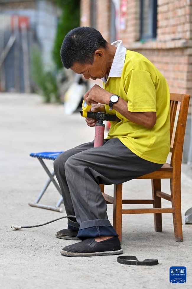 친하이쑹이 공기 펌프에 테이프를 붙이고 있다. [2025년 8월 6일 촬영/사진 출처: 신화사]