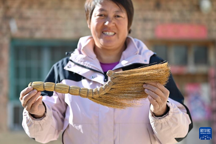 마을 주민이 친하이쑹이 만든 빗자루를 보여주고 있다. [2025년 12월 1일 촬영/사진 출처: 신화사]