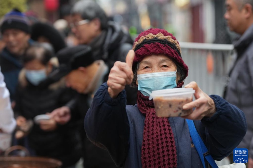 허팡제 팡후이춘탕에서 라바저우를 받은 한 노인이 엄지손가락을 치켜세우고 있다. [1월 26일 촬영/사진 출처: 신화사]