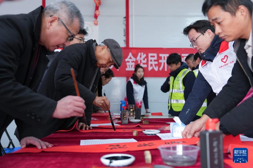 저장(浙江)성 진화(金華)철도 허브 노동자 주택 단지에서 서예 애호가들이 건설 노동자들을 위해 춘롄(春聯: 음력설에 문·기둥 등에 붙이는 주련)을 써주고 있다. [1월 24일 촬영/사진 출처: 신화사]