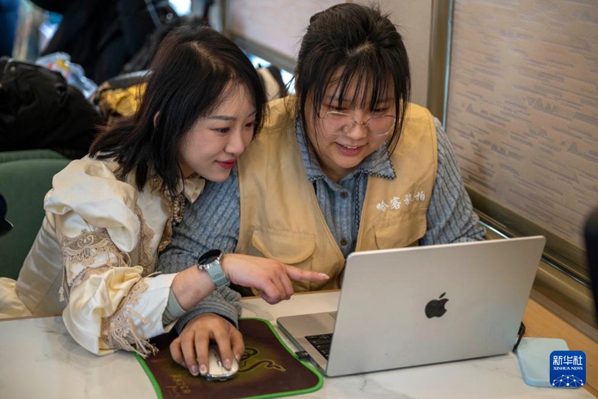 Y783편 열차에서 직원이 승객의 사진을 선별해주고 있다. [1월 25일 촬영/사진 출처: 신화사]