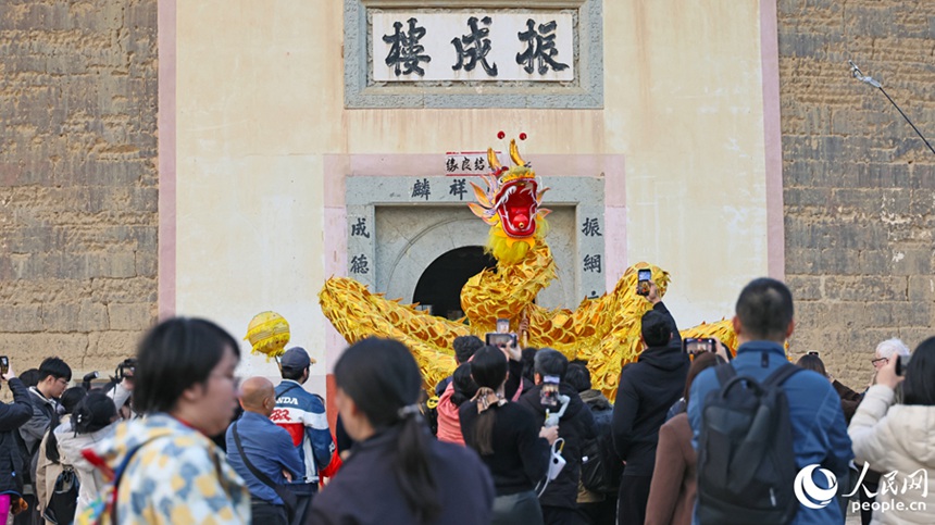 투러우 앞에서 관광객들이 용춤 공연을 구경한다. [사진 출처: 인민망]