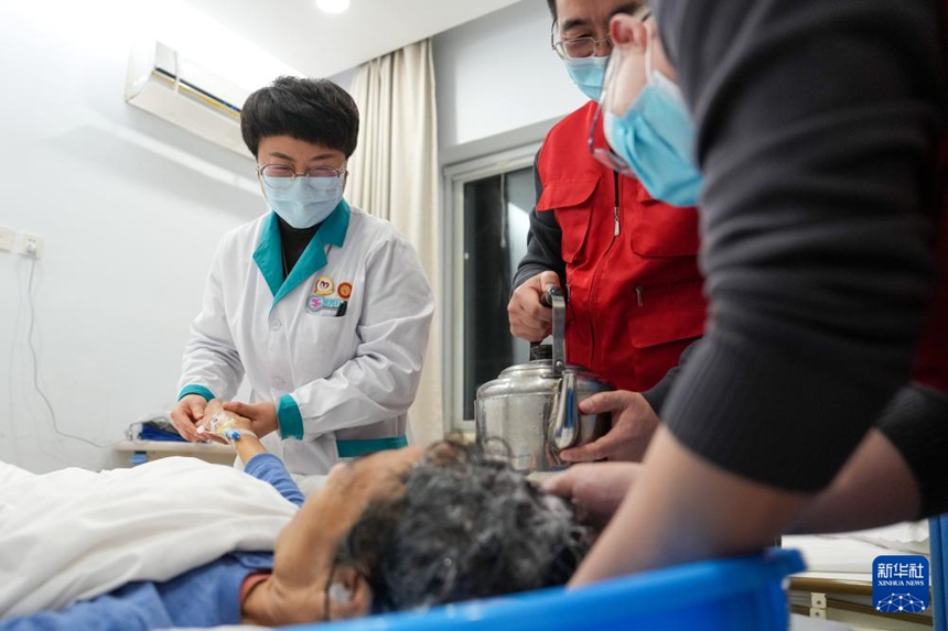 펑타이(豐臺)구 푸황위(蒲黃榆) 커뮤니티 보건센터에서 의료 사회복지사 궈추이훙(郭翠紅, 왼쪽 첫 번째)과 자원봉사자가 70세 암 환자의 머리를 감겨 드리고 있다. [사진 출처: 신화사]