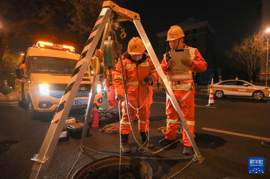 지난 4일 0시 27분경, 징넝(京能)그룹의 열배관망 운영원들이 지하 작업 전 계측기로 맨홀 내부의 각종 가스 안전 수치를 점검하고 있다. [사진 출처: 신화사]