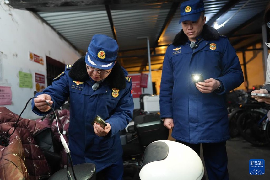 지난 3일 밤, 하이뎬(海澱)구 소방구조대 솽위수(雙榆樹) 소방서 부지휘관 왕후이쥔(王會軍, 왼쪽)과 소방관 자차오(賈超, 오른쪽)가 주택가 전기차 주차장에서 충전 설비를 점검하고 있다. [사진 출처: 신화사]