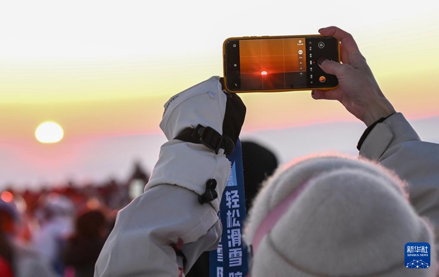 스키어가 장쥔산 국제스키리조트에서 노을을 배경으로 사진을 찍고 있다. [2월 25일 촬영/사진 출처: 신화사]