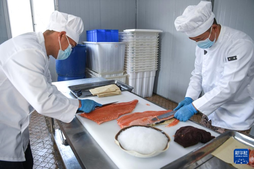 천궁현 담수어업 기지에서 작업자가 고객이 주문한 연어 살을 정성스럽게 손질하고 있다. [3월 10일 촬영/사진 출처: 신화사]