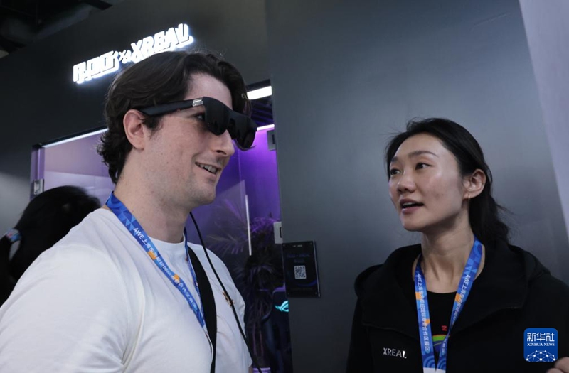 관람객(좌)이 동방 허브 전시 구역에서 스마트 안경 제품을 체험하고 있다. [3월 12일 촬영/사진 출처: 신화사]