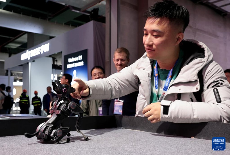 관람객이 동방 허브 전시 구역에서 훈련 가능한 1kg급 로봇개를 살펴보고 있다. [3월 12일 촬영/사진 출처: 신화사]