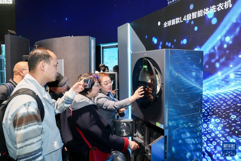 관람객들이 L4급 스마트 세탁기에 대해 설명을 듣고 있다. [3월 12일 촬영/사진 출처: 신화사]