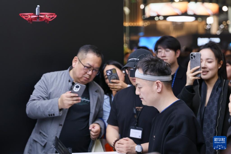 상하이 신국제박람센터 드리미 테크놀로지(追覓科技, DREAME) 전시 부스의 뇌-컴퓨터 인터페이스(BCI) 전시 구역에서 관계자가 뇌파를 통해 드론을 조종하는 것을 시연하고 있다. [3월 12일 촬영/사진 출처: 신화사]