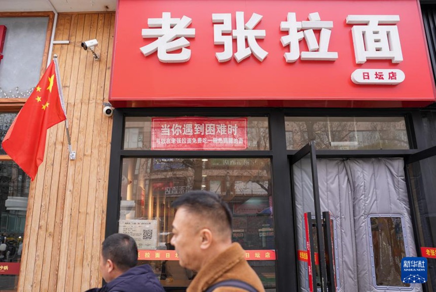 베이징시 차오와이가도에 있는 라오장 라몐집 입구에 “당신이 어려움을 겪을 때 언제든 무료로 뜨끈한 라오장 라몐 한 그릇 대접합니다”라는 글귀가 쓰여 있다. [2월 27일 촬영/사진 출처: 신화사]