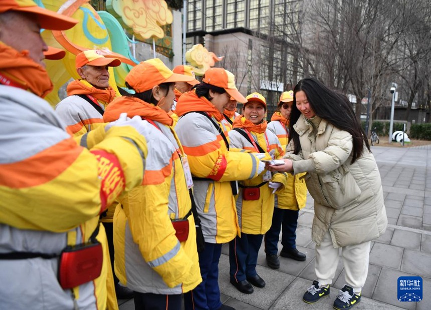 차오와이가도에서 일을 마친 선도원들에게 ‘사랑의 라몐 카드’를 지급한다. [2월 27일 촬영/사진 출처: 신화사]