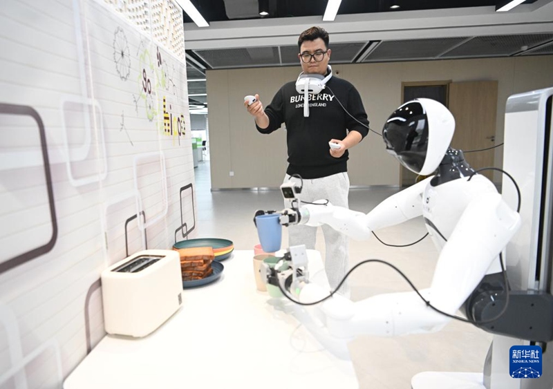 중국 슝안그룹 디지털도시테크놀로지 유한공사 구신지능 훈련장에서 관계자가 로봇에 대한 훈련을 진행하고 있다. [3월 17일 촬영/사진 출처: 신화사]