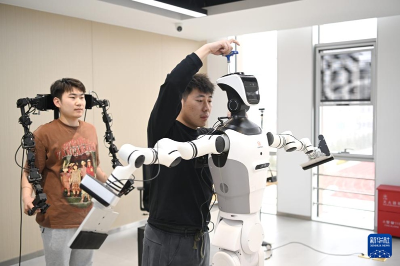 관계자가 로봇을 조정하고 있다. [3월 17일 촬영/사진 출처: 신화사]