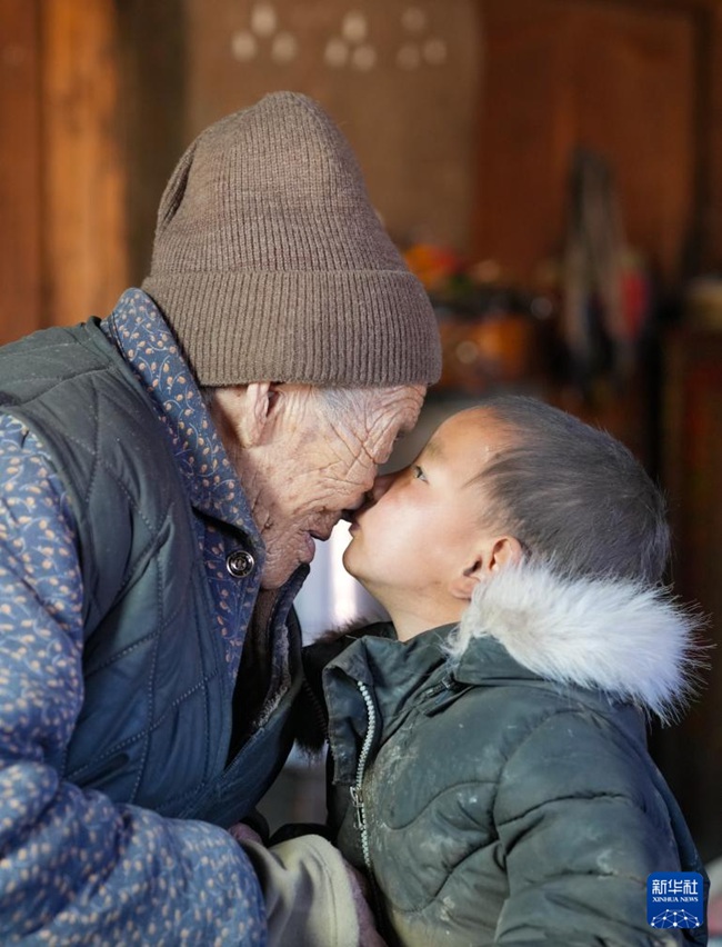 92세 여동생 츠줘라무가 손주에게 뽀뽀를 하고 있다. [3월 6일 촬영/사진 출처: 신화사]
