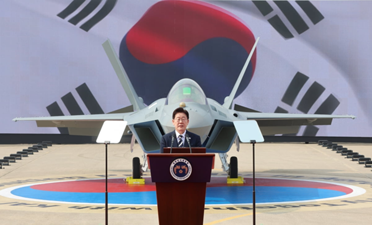 이재명 대통령이 25일 경남 사천 한국항공우주산업(KAI)에서 열린 KF-21 양산 1호기 출고식에서 격려사를 하고 있다. [사진 출처: 한국경제신문]