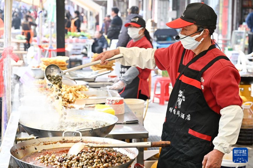 우렁이 미식 관광 시즌 장터에서 직원들이 우렁이를 조리하고 있다. [3월 21일 촬영/사진 출처: 신화사]
